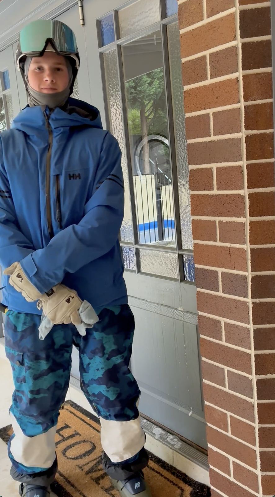 Hugh in full ski gear at a customer's front door